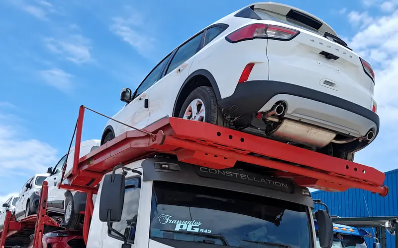 Detalle de una camioneta blanca sobre la plataforma superior de una niñera de Transautos PG.
